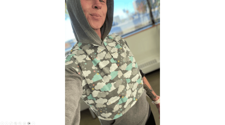 A person wearing a hoodie underneath a crop top vest that she designed and sewed and made herself fashion designer bodice block close fitting cloud computer SaaS clothing with Beyond ha ha photo 01 of 02